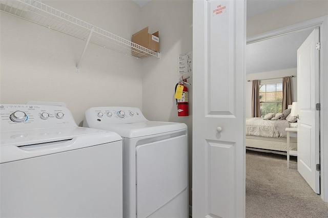 laundry room with light colored carpet and washer and dryer