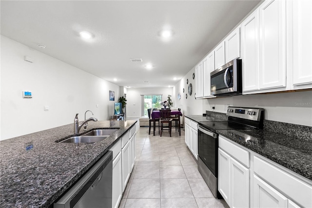 kitchen featuring sink, white cabinets, stainless steel appliances, and dark stone counters