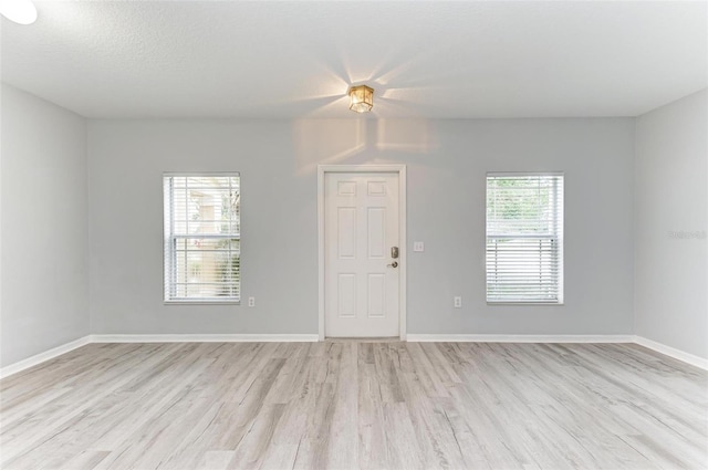 spare room with light hardwood / wood-style floors and a textured ceiling