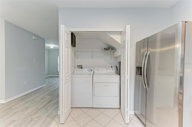 washroom with washer and clothes dryer and light tile patterned floors