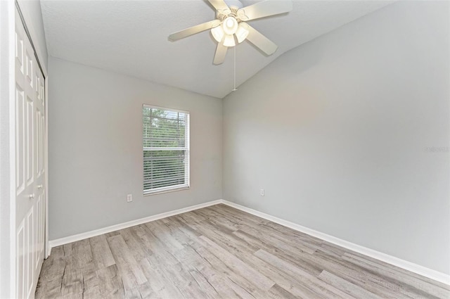 unfurnished room with ceiling fan, light hardwood / wood-style flooring, and vaulted ceiling