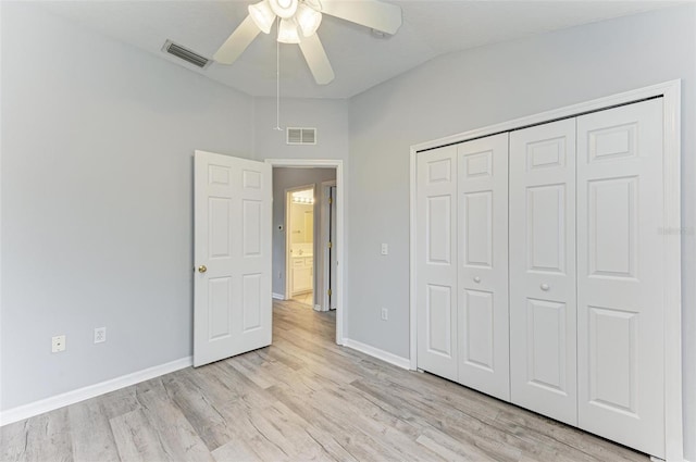 unfurnished bedroom featuring ceiling fan, lofted ceiling, light wood-type flooring, and a closet