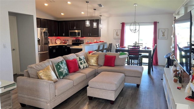 living room featuring dark hardwood / wood-style flooring, a chandelier, lofted ceiling, and sink