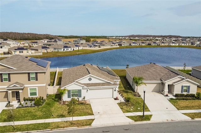 view of front facade with a water view, solar panels, and a garage