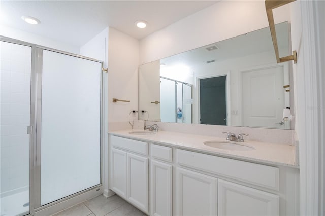 bathroom with a shower with shower door, tile floors, double sink, and large vanity