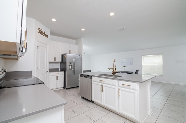 kitchen featuring white cabinetry, sink, stainless steel appliances, light tile floors, and a center island with sink