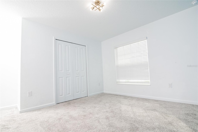 unfurnished bedroom featuring a closet and light colored carpet