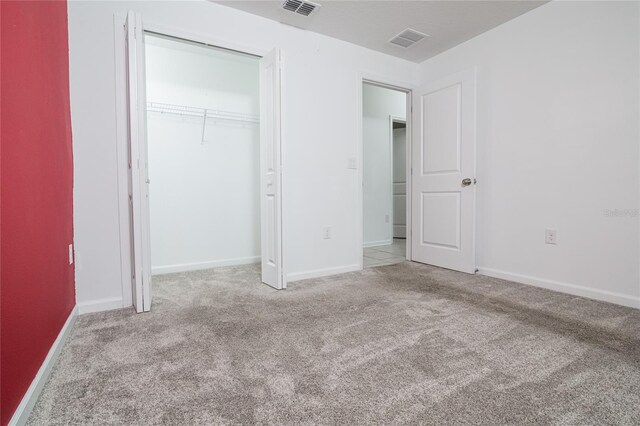 unfurnished bedroom featuring a closet and light colored carpet