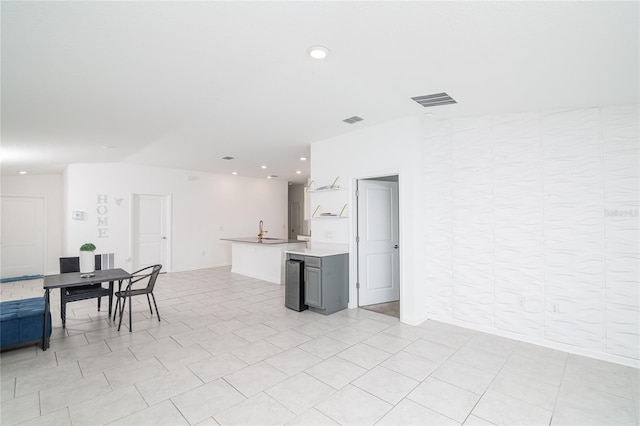 kitchen featuring gray cabinetry, sink, and light tile floors