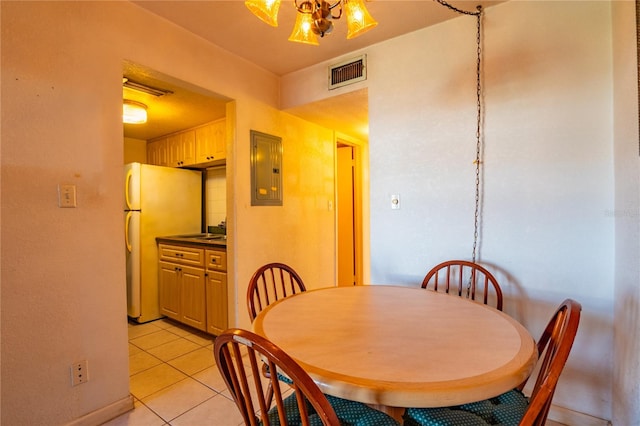 tiled dining area featuring a chandelier