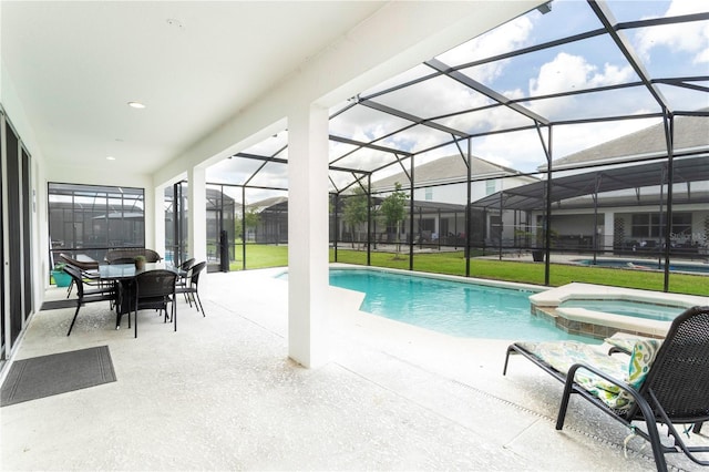 view of pool with a patio area, an in ground hot tub, a lawn, and glass enclosure