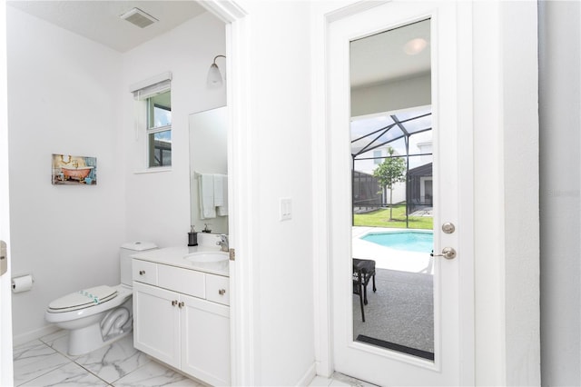 bathroom with a wealth of natural light, tile floors, large vanity, and toilet