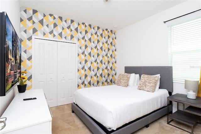 bedroom featuring a closet and light colored carpet