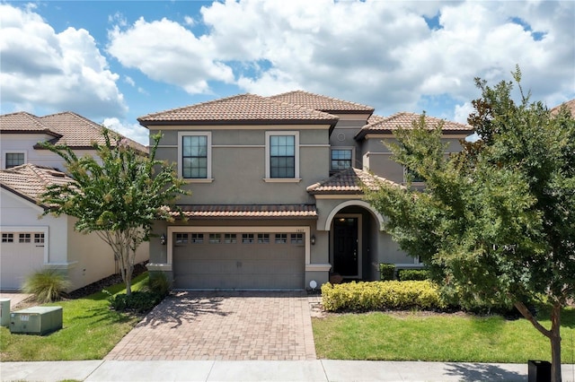 mediterranean / spanish-style home featuring a front yard and a garage