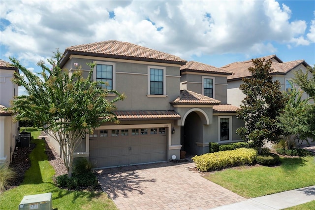 mediterranean / spanish-style home featuring a front yard and a garage