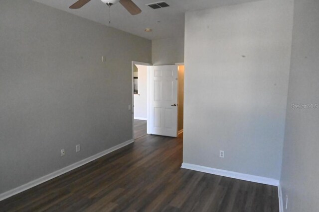 spare room with dark hardwood / wood-style floors and ceiling fan