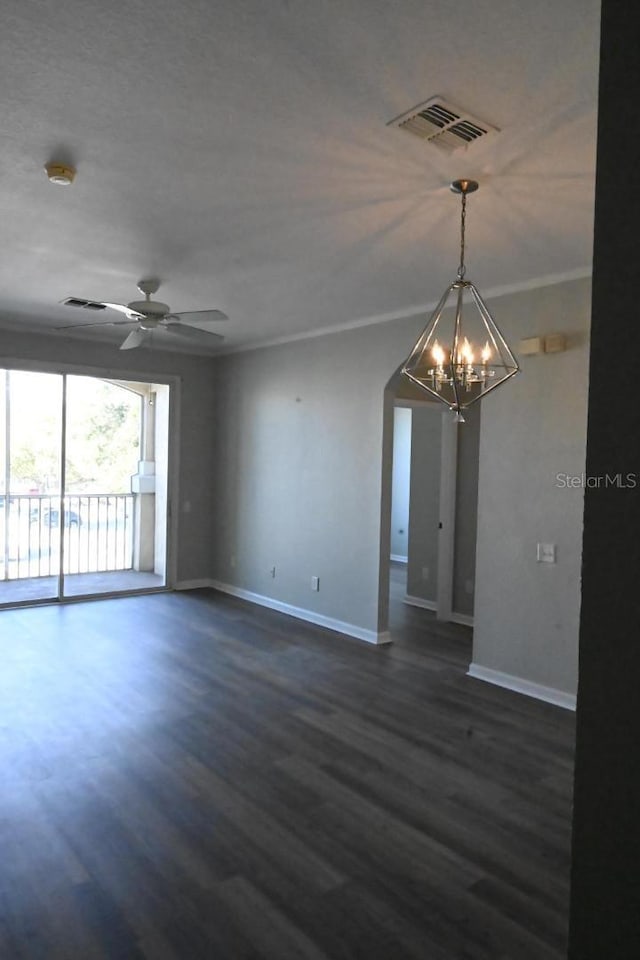 spare room with dark hardwood / wood-style floors, ornamental molding, and ceiling fan with notable chandelier