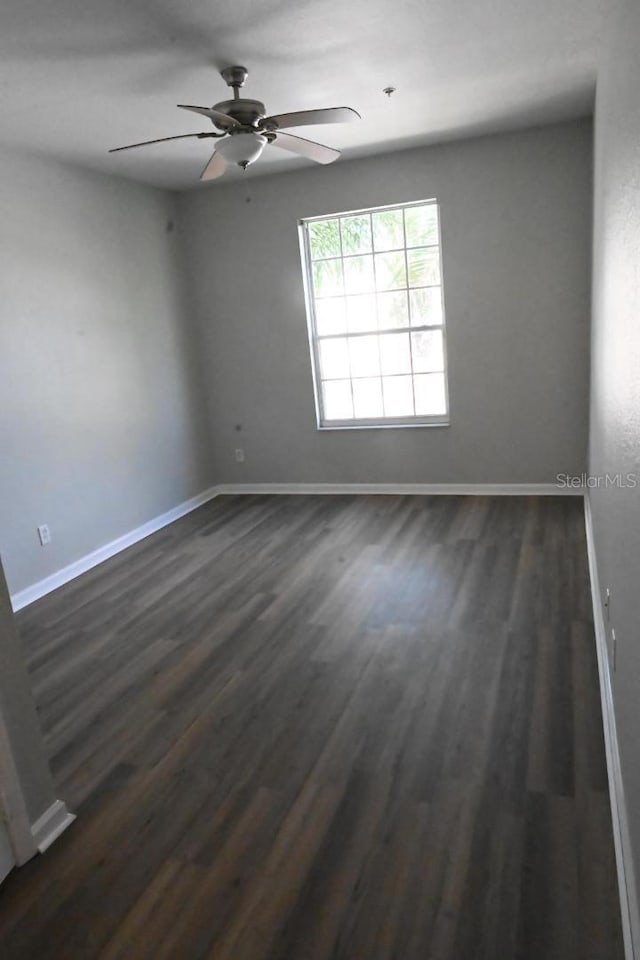 spare room featuring ceiling fan and dark hardwood / wood-style floors