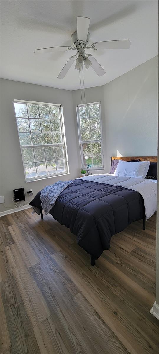 bedroom with dark wood-type flooring and ceiling fan