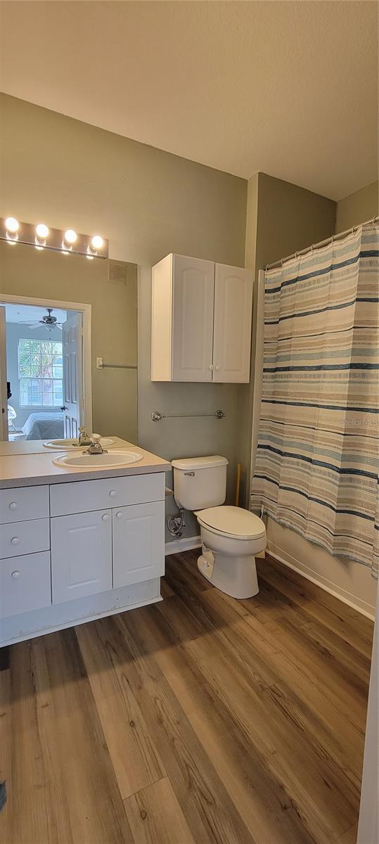 bathroom featuring vanity, ceiling fan, wood-type flooring, and toilet