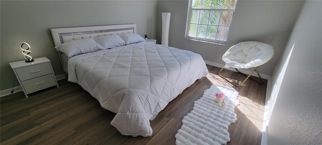 bedroom with dark wood-type flooring