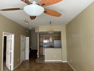 interior space with dark tile floors and ceiling fan