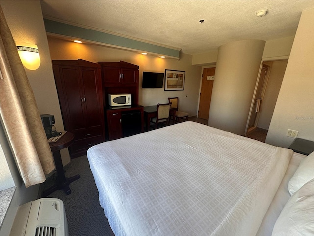 bedroom featuring a textured ceiling and carpet floors