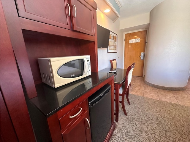 kitchen featuring light tile floors, water heater, and dishwasher