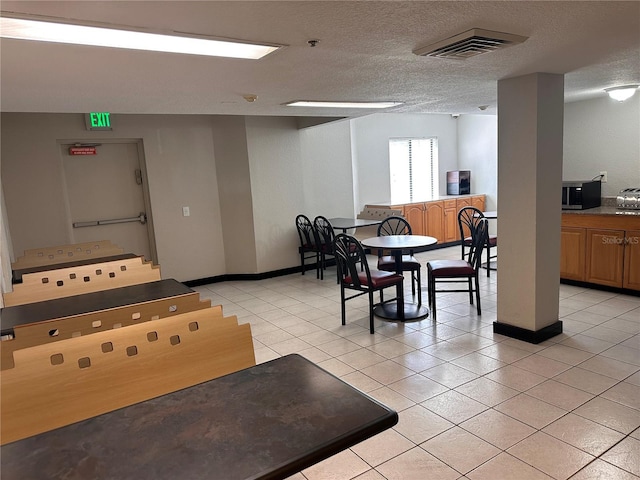 dining area with light tile flooring and a textured ceiling