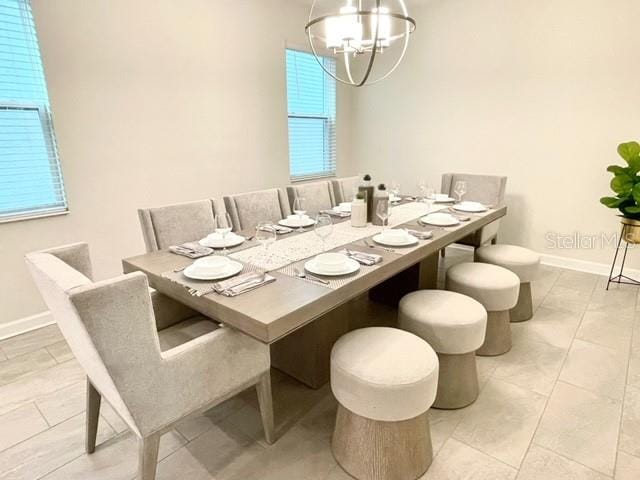 tiled dining room with a chandelier