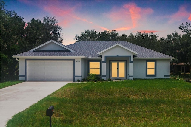 ranch-style home with a garage and a lawn