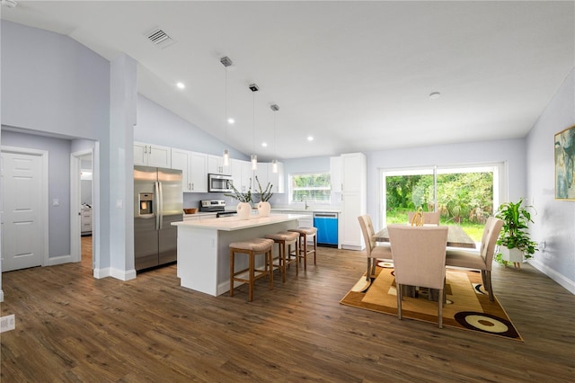 kitchen featuring appliances with stainless steel finishes, hanging light fixtures, a kitchen island, dark hardwood / wood-style floors, and white cabinetry