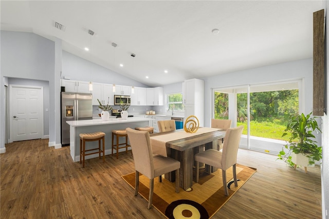 dining room featuring high vaulted ceiling and wood-type flooring