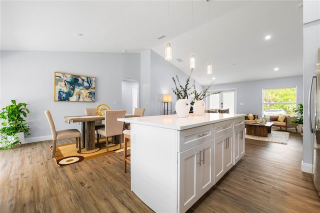 kitchen featuring decorative light fixtures, white cabinets, dark hardwood / wood-style floors, and a kitchen island