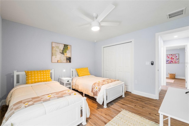 bedroom with light hardwood / wood-style floors, a closet, and ceiling fan