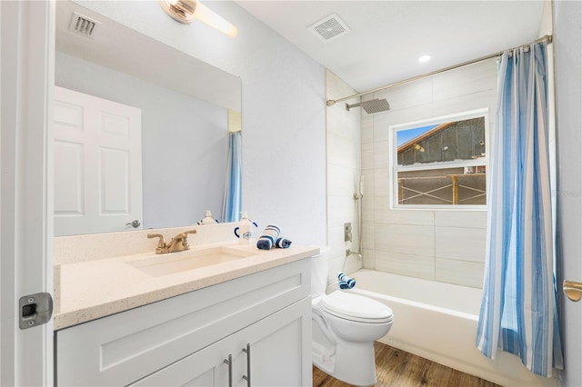 full bathroom with hardwood / wood-style flooring, toilet, shower / bathtub combination with curtain, and vanity