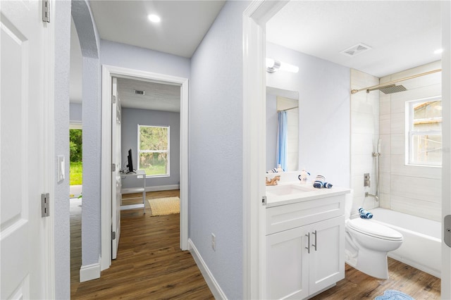 full bathroom featuring tiled shower / bath combo, vanity, wood-type flooring, and toilet