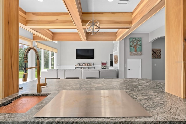 kitchen with coffered ceiling, a notable chandelier, and beamed ceiling