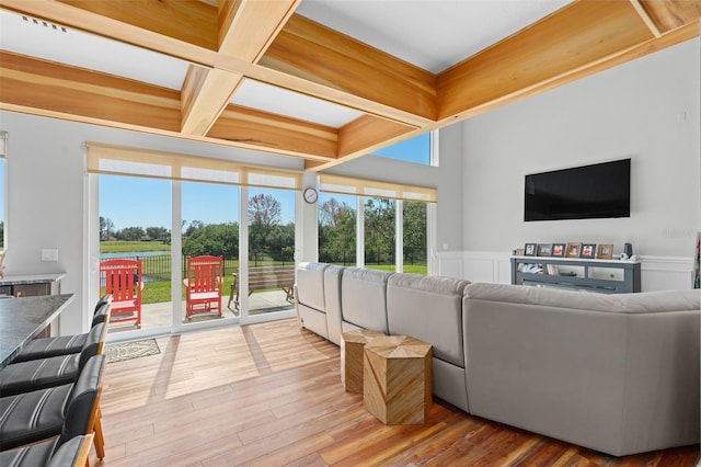 living room featuring beamed ceiling, wood-type flooring, and coffered ceiling