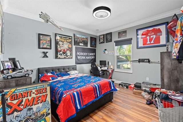 bedroom featuring hardwood / wood-style flooring, ornamental molding, and a textured ceiling