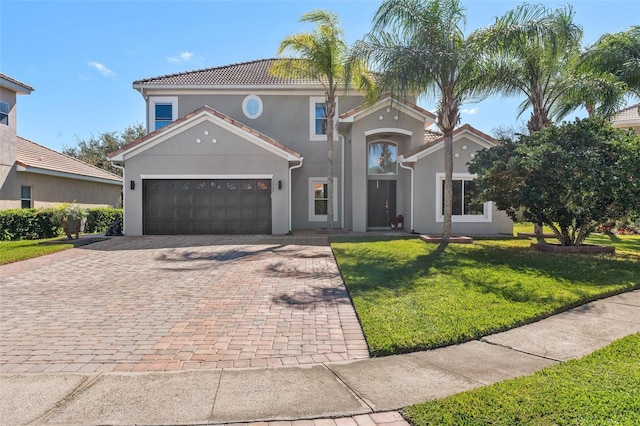 mediterranean / spanish-style home featuring a garage and a front lawn