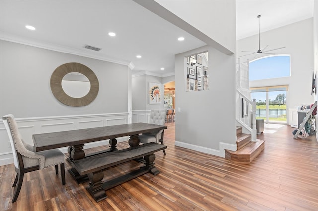 dining space with hardwood / wood-style flooring, ornamental molding, and ceiling fan