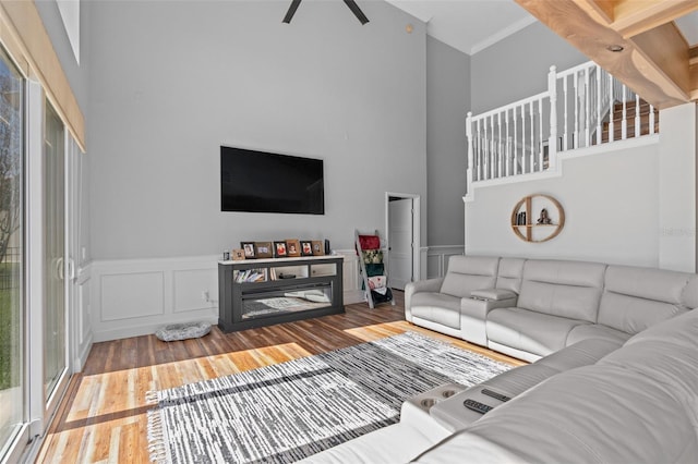 living room featuring hardwood / wood-style flooring, plenty of natural light, and a towering ceiling