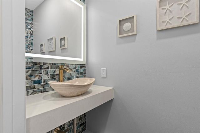 bathroom with sink and decorative backsplash