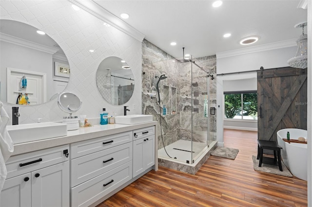 bathroom with crown molding, wood-type flooring, plus walk in shower, and vanity