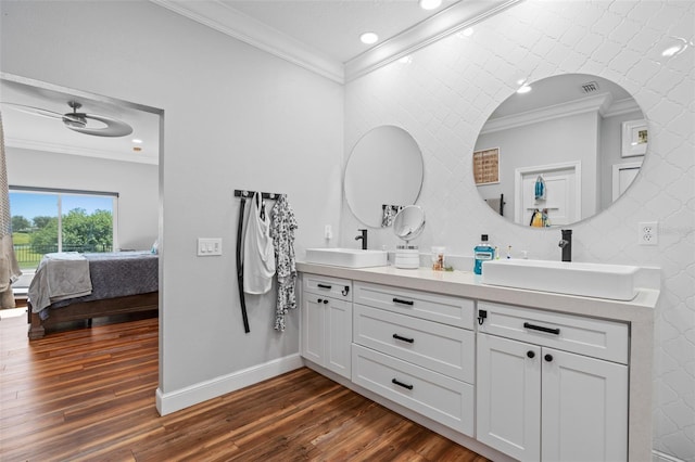 bathroom with crown molding, wood-type flooring, and vanity