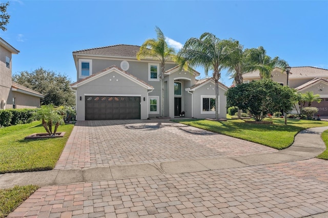 mediterranean / spanish-style home featuring a garage and a front yard