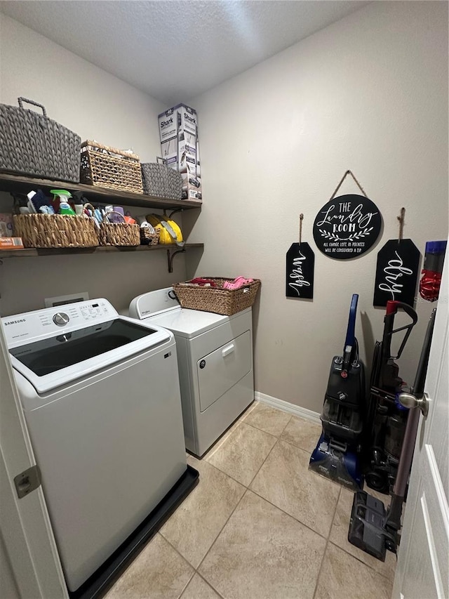 clothes washing area featuring washing machine and dryer and light tile floors