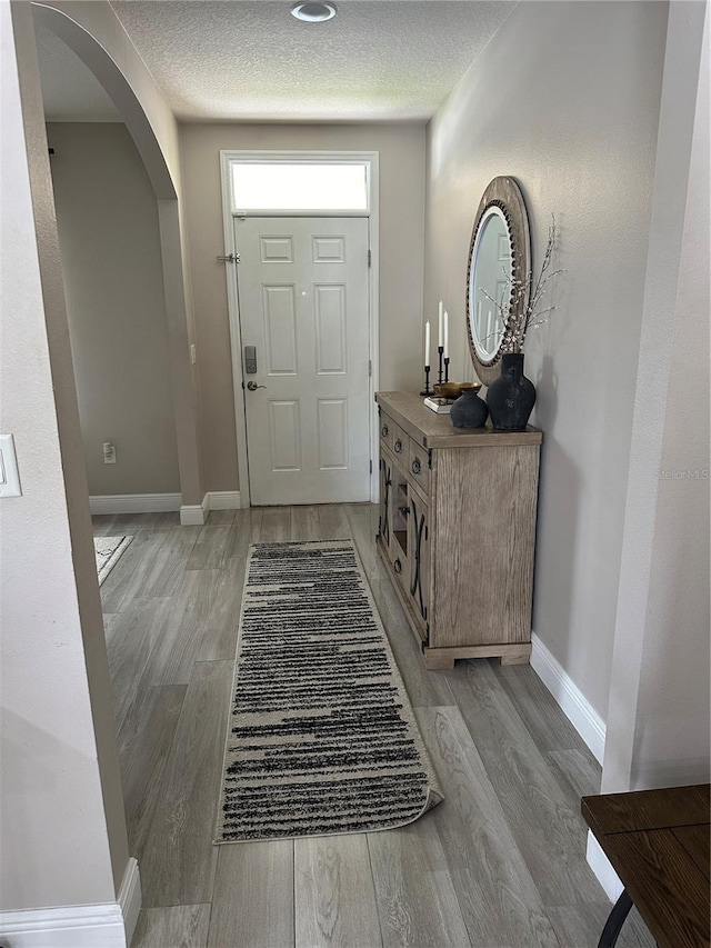 entryway featuring a textured ceiling and light wood-type flooring