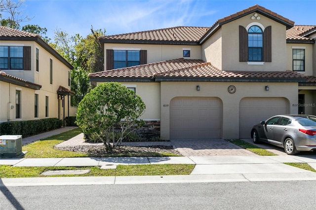 mediterranean / spanish-style home with cooling unit and a garage